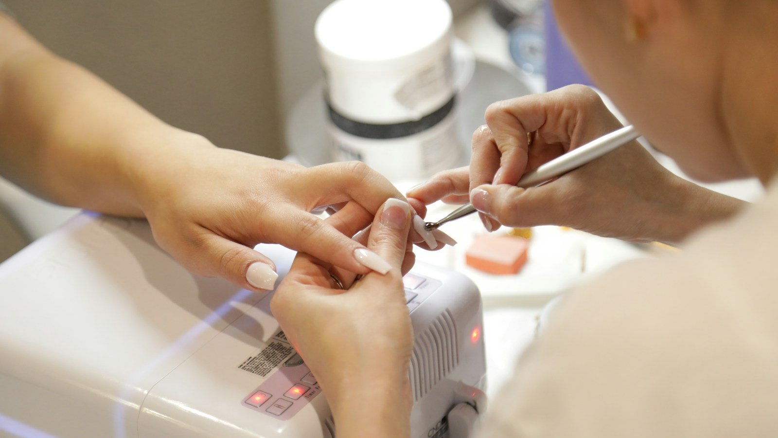 Nail technician doing a manicure in a busy salon