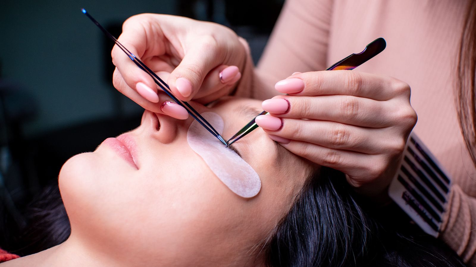 Lash artist applying eyelash extensions in a beauty salon