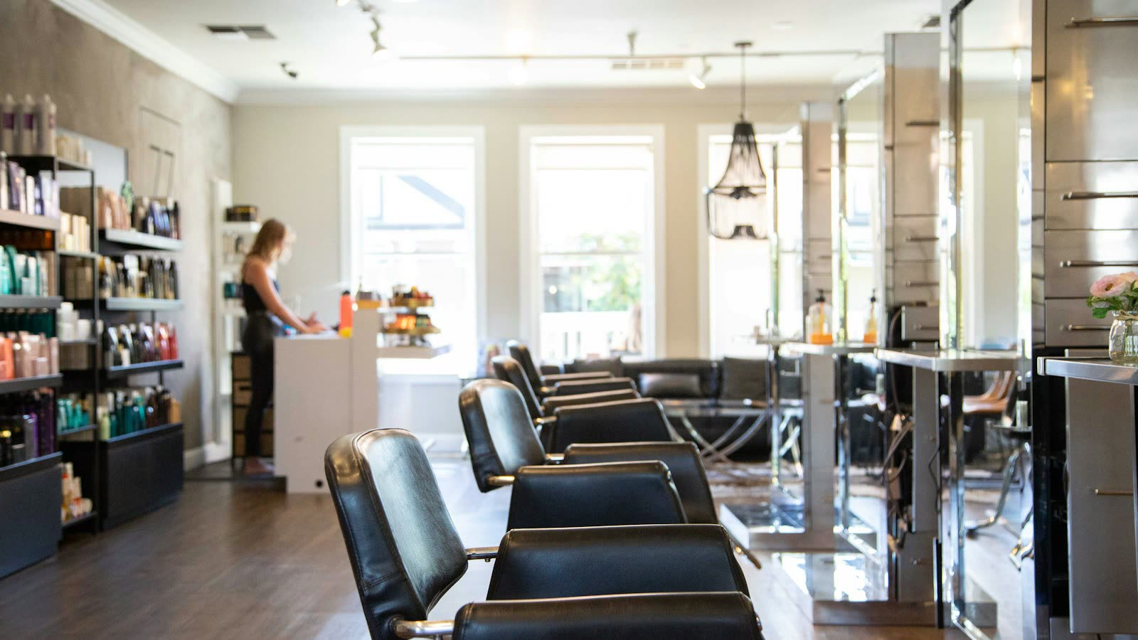 Bright beauty salon with styling chairs and large windows